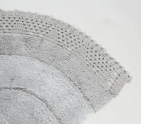 Close-up detail of the hand tufted grey cotton bath mat