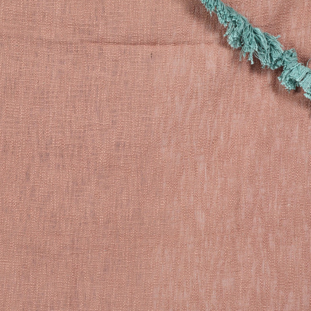 Dusty pink throw blanket at the foot of a bed