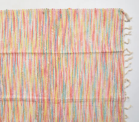 Multicolor throw blanket paired with cushions