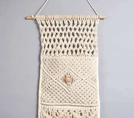 Macrame wall hanging with pocket above a study desk