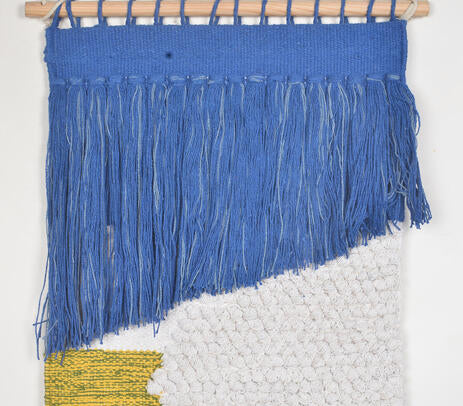 Coastal tasseled wall hanging shown with hanging rod detail