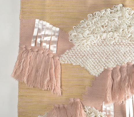 Earthy tufted wool wall hanging shown with hanging rod detail