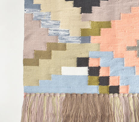 Colour block wool wall hanging shown with hanging rod detail
