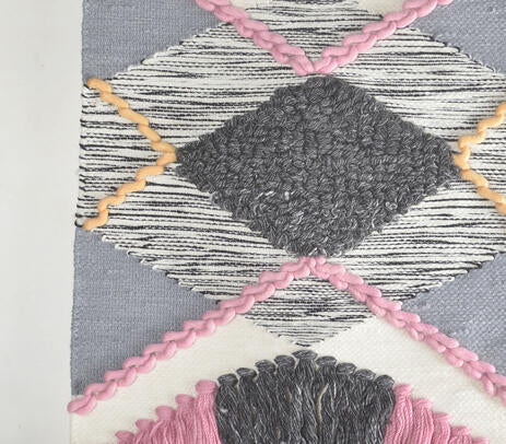 Pink tufted wool wall hanging with hanging rod detail