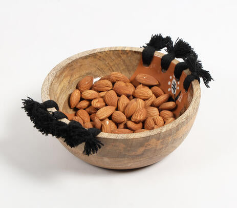 Tasseled wooden bowl styled on a table