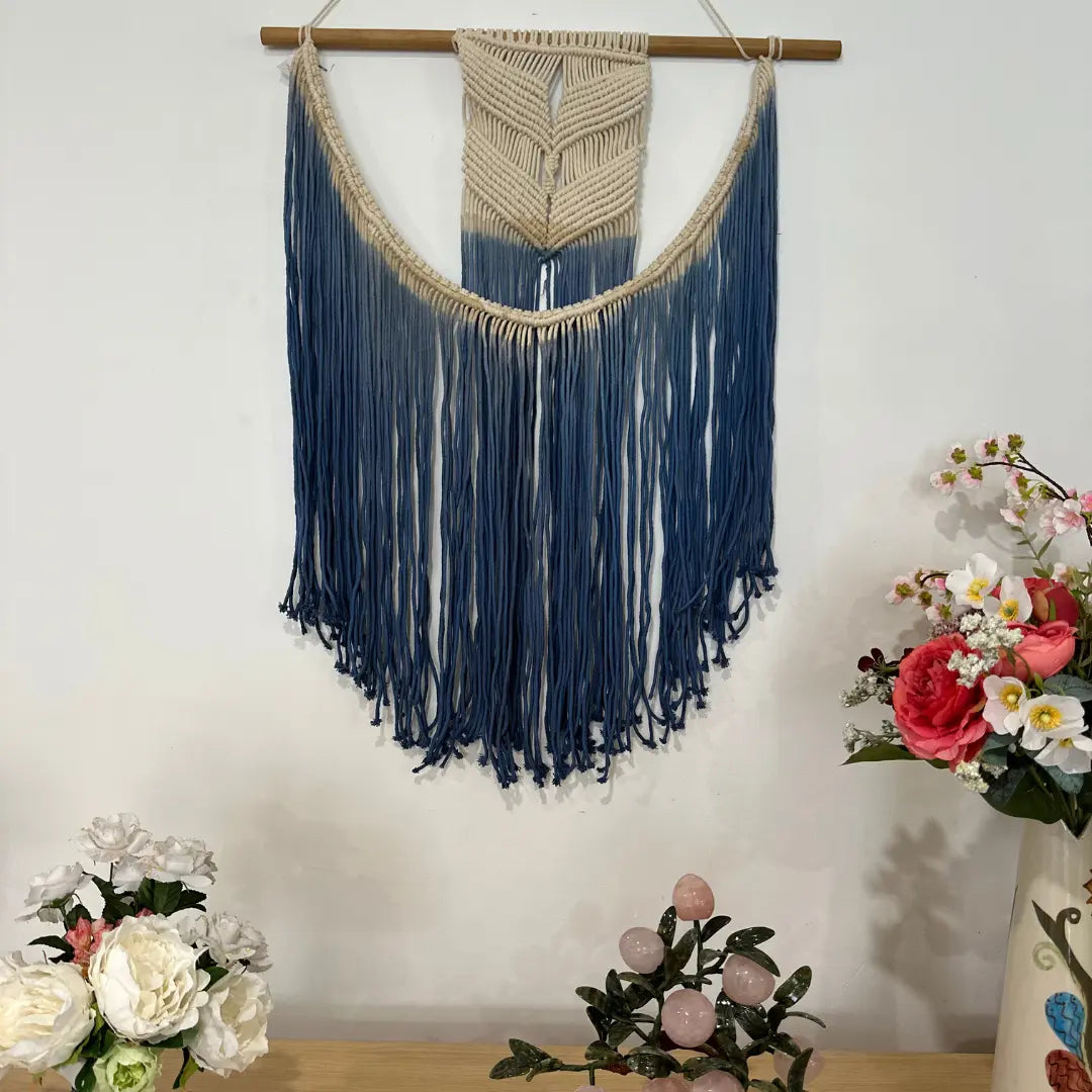 Blue ombre macrame wall hanging styled in a coastal room