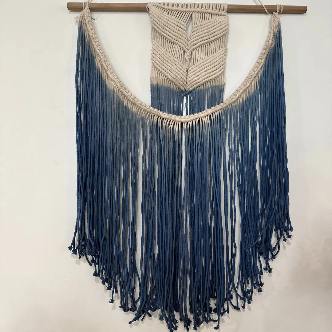 Blue ombre macrame wall hanging shown at an angle