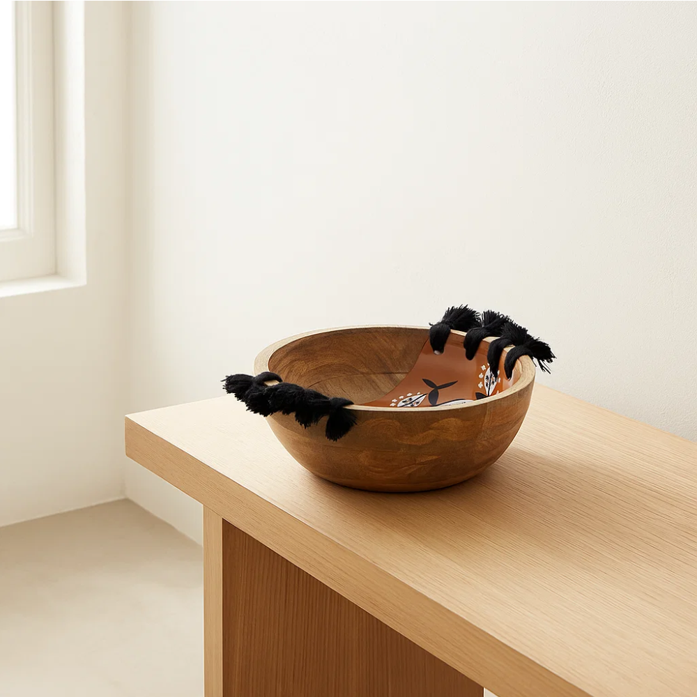 Tasseled wooden bowl with food
