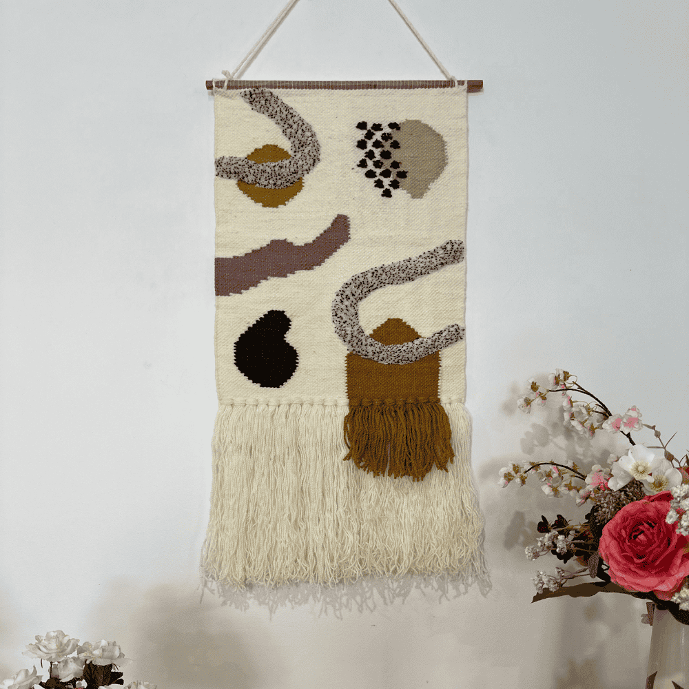 Layered fringe wool wall hanging beside a plant