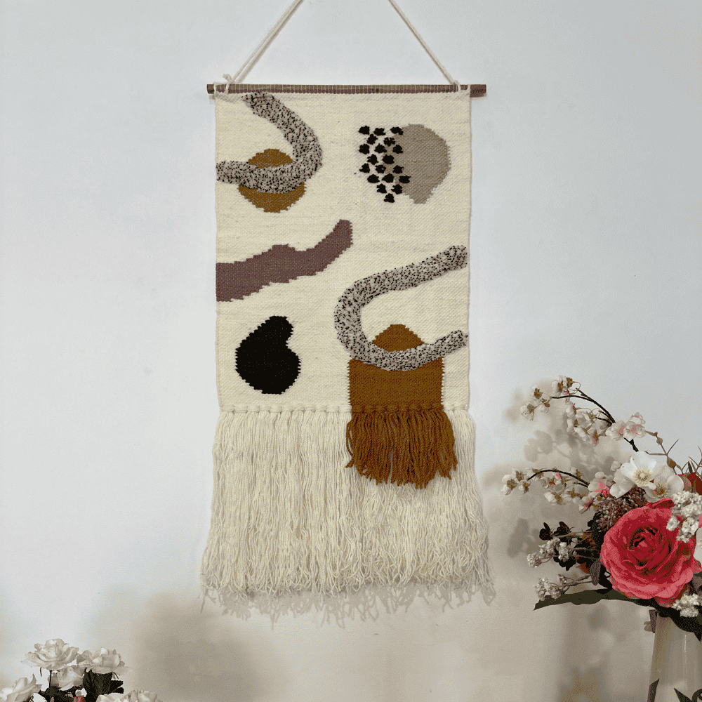 Layered fringe wool wall hanging above a console table