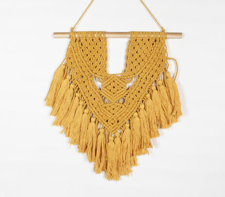 Mustard macrame wall hanging above a desk
