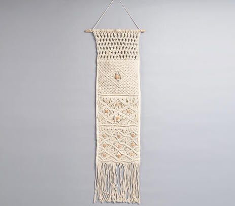 Macrame wall hanging with pocket on a plain wall