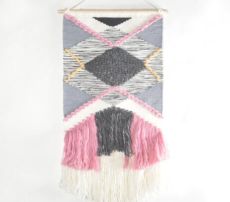 Pink tufted wool wall hanging on a plain wall
