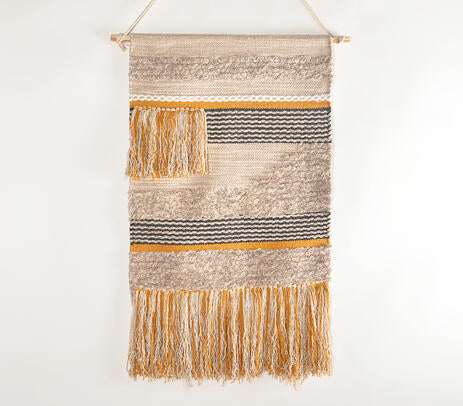 Multicolour cotton fringe wall hanging on a neutral plaster wall