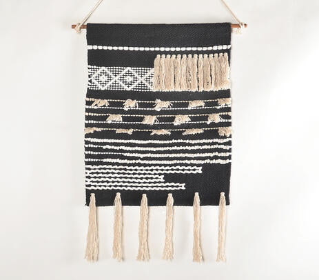 Textured cotton tassel wall hanging on a painted plaster wall