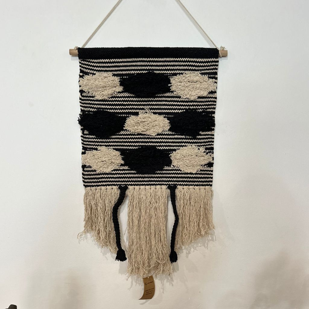 Black and cream striped cotton wall hanging on a painted plaster wall