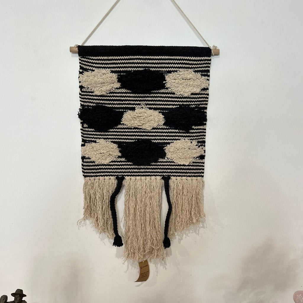 Black and cream striped cotton wall hanging close-up of hand-tied tassel detail
