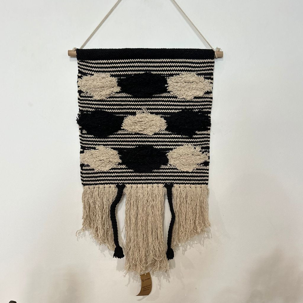 Black and cream striped cotton wall hanging styled in a minimalist bedroom