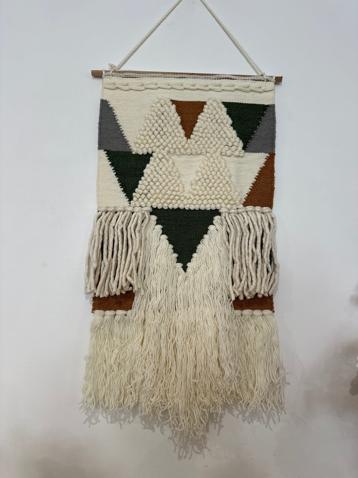Loop and pile wool wall hanging in a styled bedroom