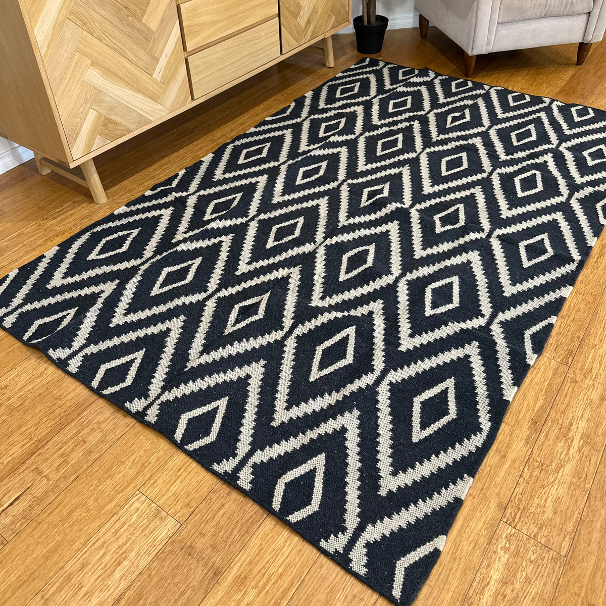 Rug shown partly turned back to reveal its reverse