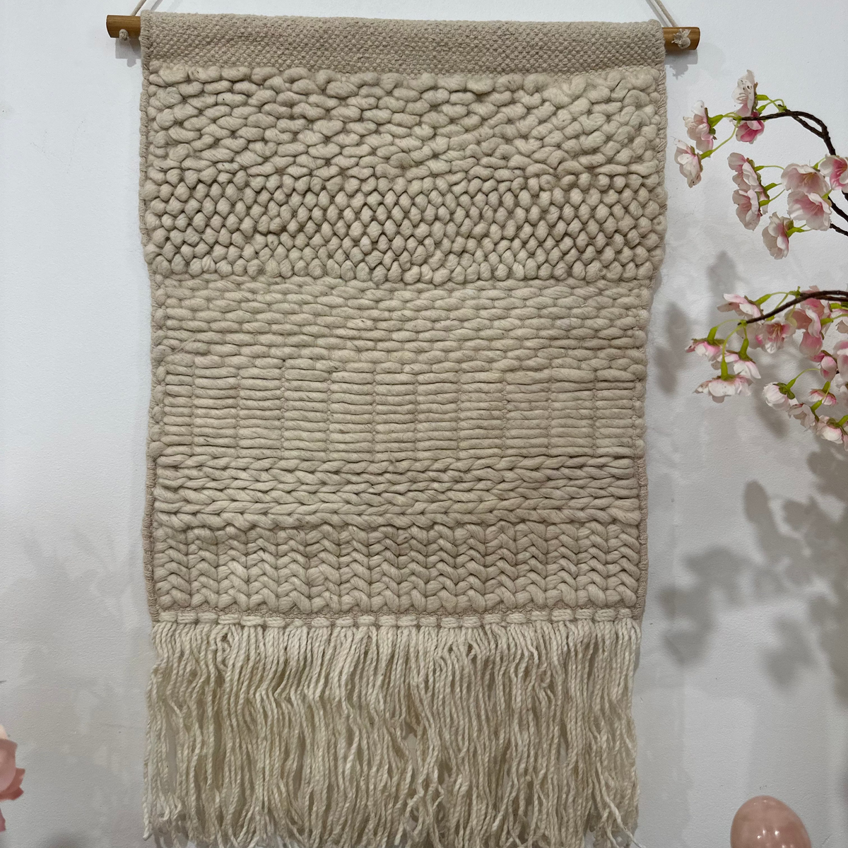Boho wool fringe wall hanging on a plain wall