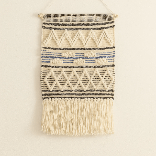 Geometric wool and cotton wall hanging on a plain wall