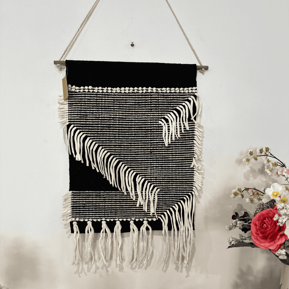 Monochrome cotton fringe wall hanging styled in a bedroom